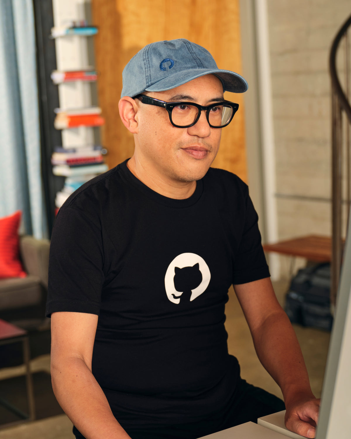 man wearing Invertocat 2.0 Hat at his desk.