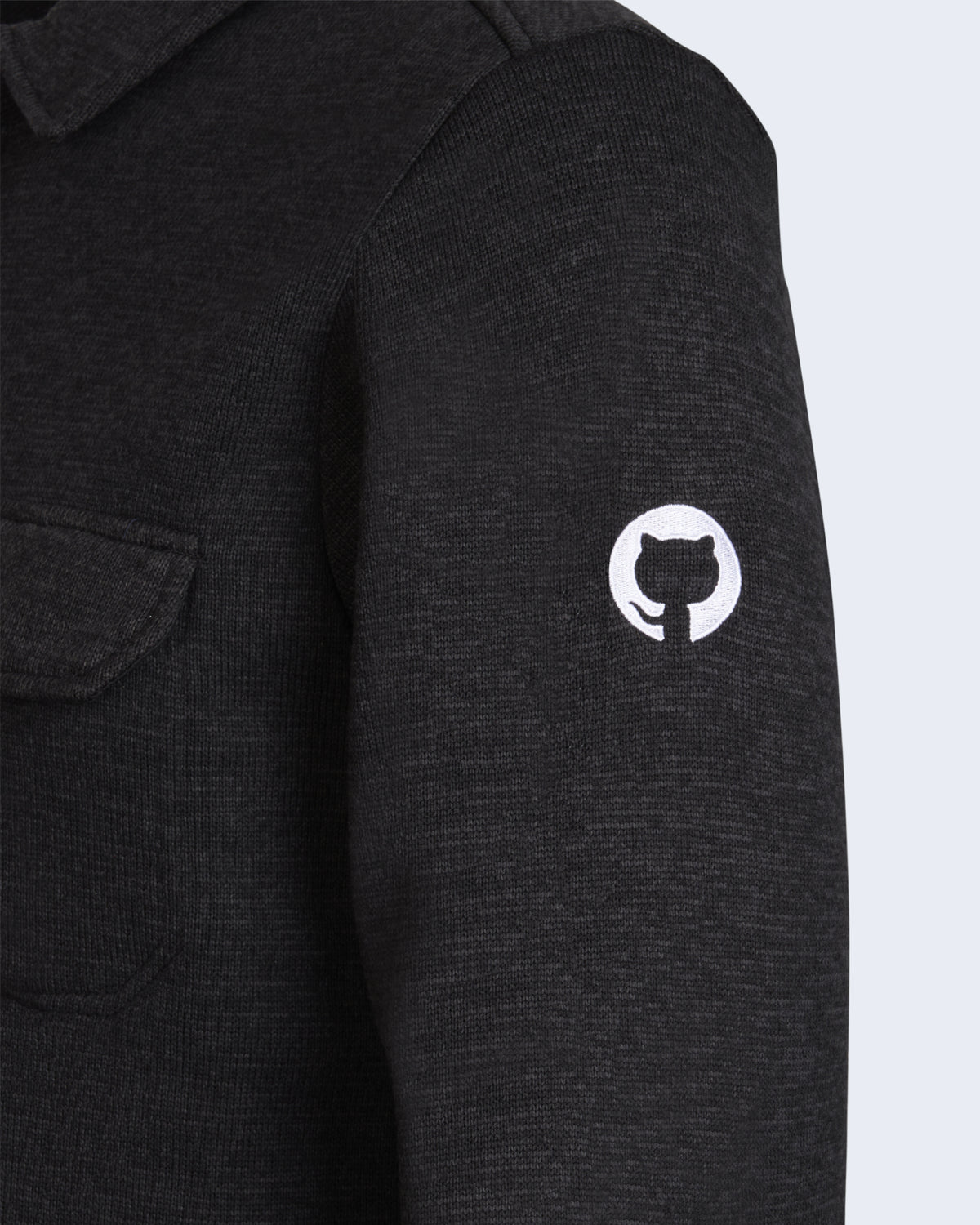 Detail close-up of left sleeve of black avalanche fleece shacket showing the white Invertocat logo embroidery.