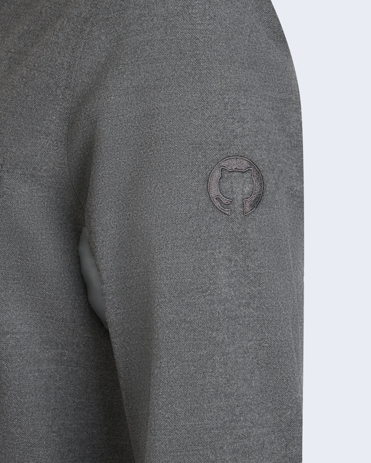 Close-up view of Twill button-up shirt in gray featuring the embroidered gray Invertocat logo on the left sleeve.
