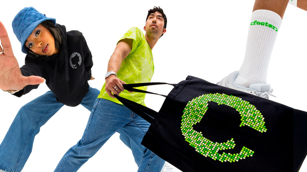 Two people wearing GitHub merchandise with a focus on a black bag with green design.