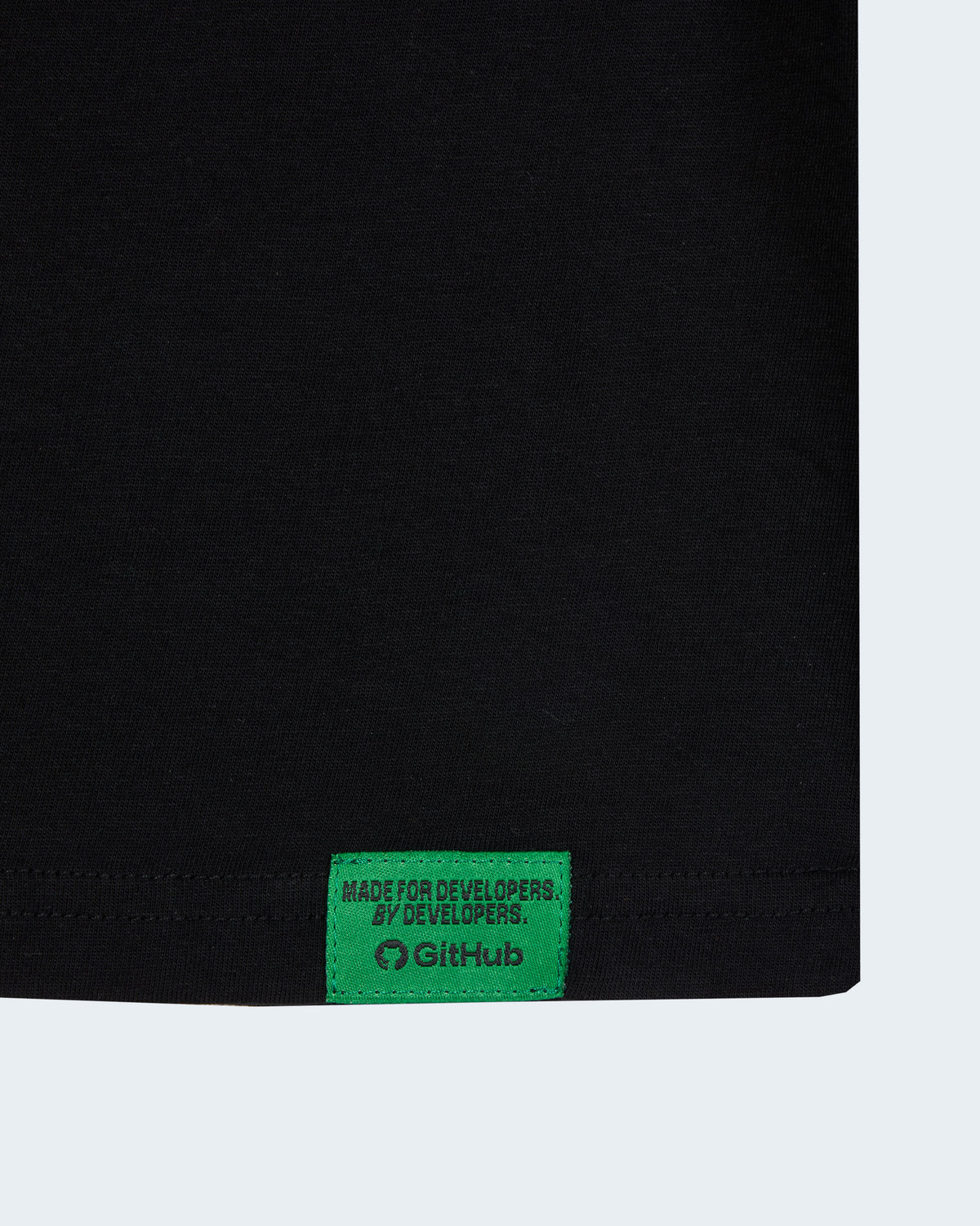 Close-up of Black t-shirt featuring the green GitHub label on the hem