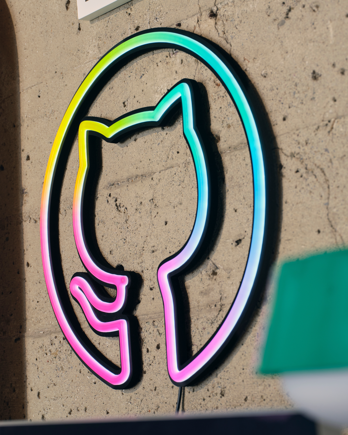 Invertocat LED sign lit and mounted on the wall