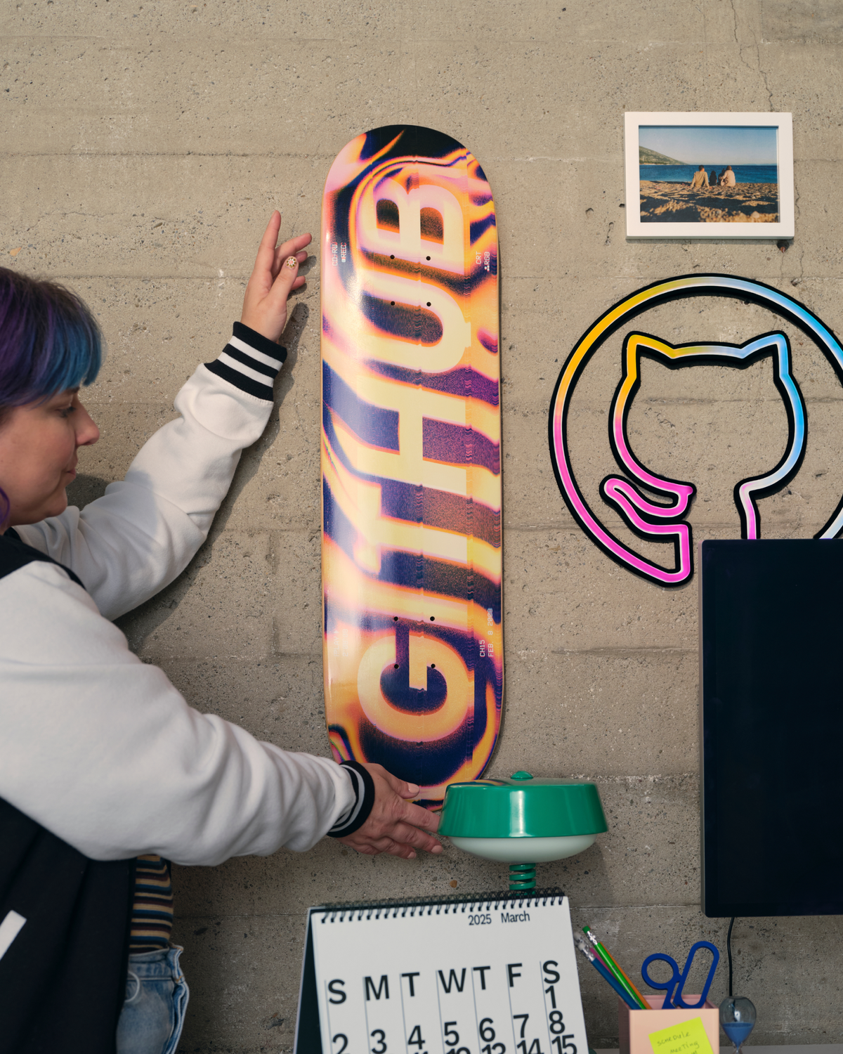 woman placing GitHub Skateboard on wall.