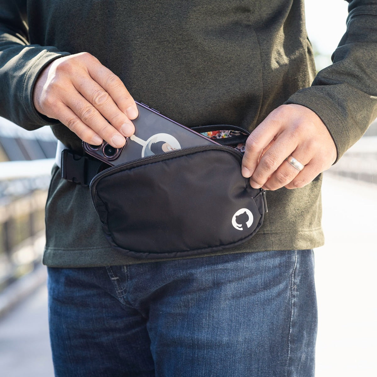 Photo of man placing phone into Sticker Collage Belt Bag