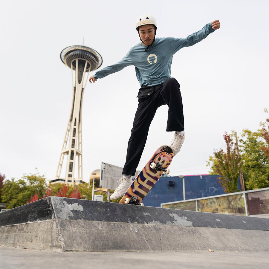 Photo of man skateboarding at skate park wearing Invertocat 4.0 Long Sleeve Shirt in blue. 