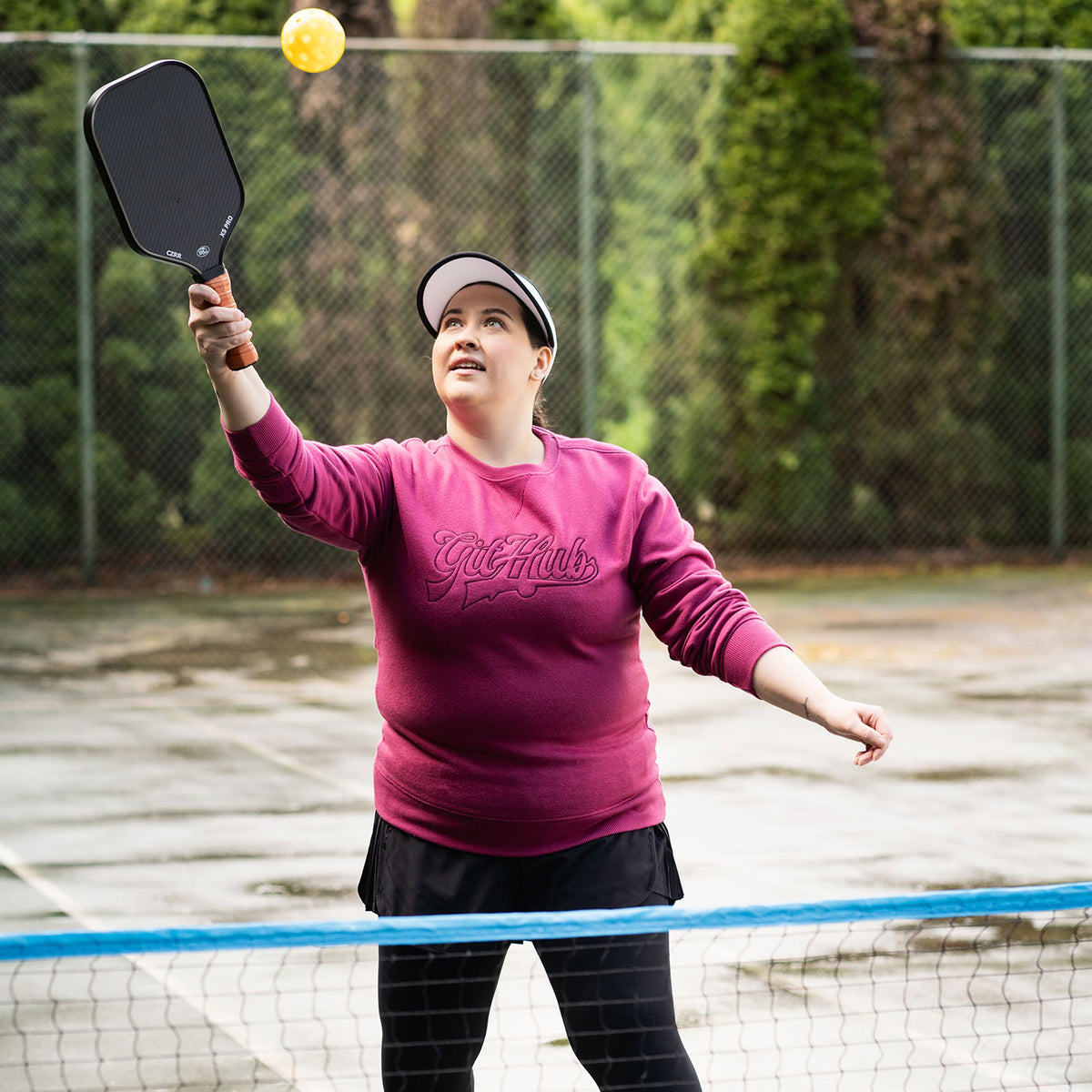 Photo of woman playing pickleball wearing Varsity Crewneck Sweatshirt in Maroon