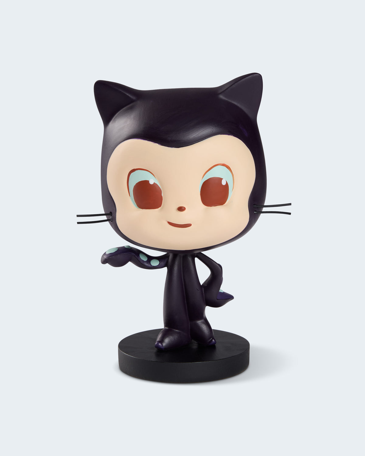 A stylized collectible figurine of a Mona head and body, cream face, large brown eyes, and a black circular base.