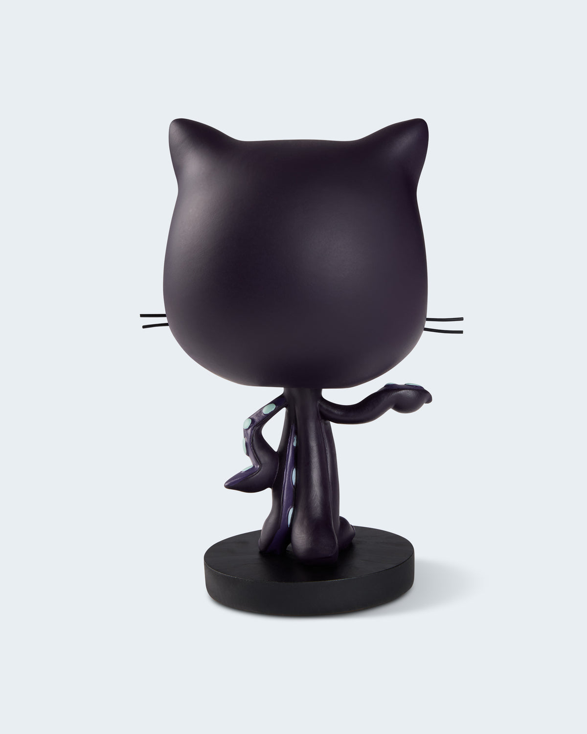 A matte black cat-shaped figurine standing on a round black base,