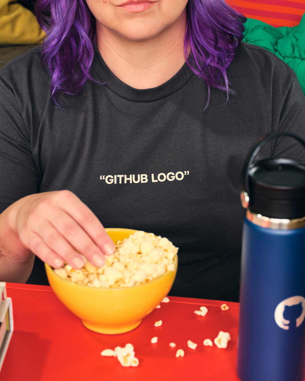 Photo of woman with purple hair wearing Air Quotes shirt in grey.