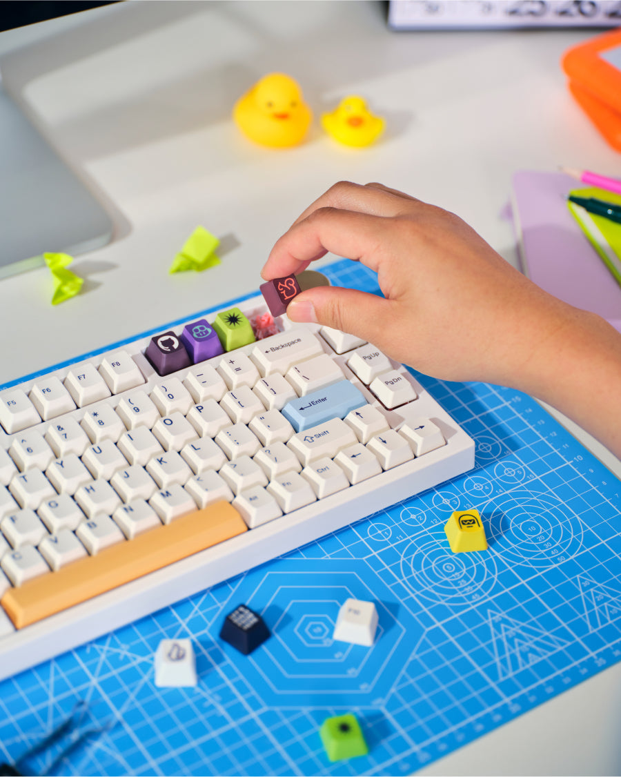 Photo of person installing GitHub Keycaps on mechanical keyboard.